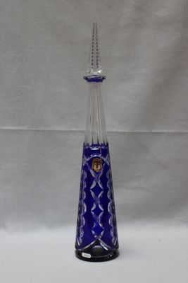 une image représentant un vase en verre bleu orné d'un couvercle en argent