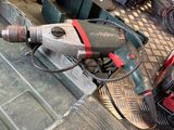 a drill that is sitting on the floor next to a tool box