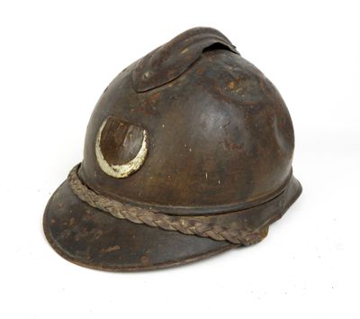 un vieux casque de pompier avec une corde autour du bord