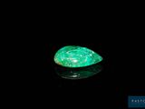 a close up of a green stone on a black surface