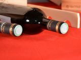 three bottles of wine sitting on a red table