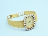 an antique ladies ' s watch with a gold band and diamonds
