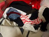 a suitcase full of clothes and a cat sitting on the floor