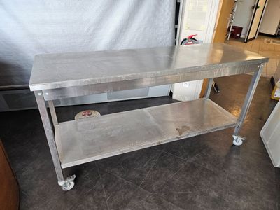 a stainless steel table on wheels in a kitchen