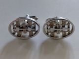 pair of silvertoned cuff earrings with geometric design on white surface