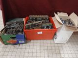 de nombreuses boîtes contenant des trains miniatures de toutes sortes, posées par terre