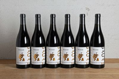 six bouteilles de vin sont alignées sur une table en bois