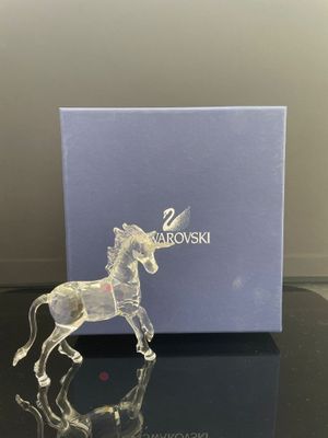 une figurine de licorne en verre transparent posée sur une table