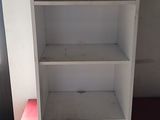 a red cabinet and a white shelf in a room