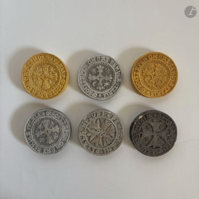 quatre types de pièces différents posés sur une surface blanche