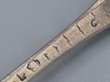 a silver spoon with writing on it sitting on a table