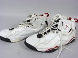 une paire de baskets blanches et noires avec des touches de rouge sur fond blanc