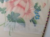 a fan with a floral design on it on a table