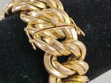 a close up of a gold bracelet on a black ring