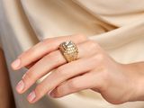 someone is wearing a gold ring with a diamond on it