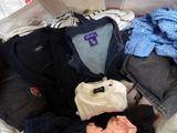 un tas de vêtements dans un panier posé sur un lit