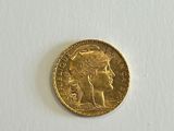a close up of a gold coin on a white surface