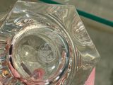a person holding a glass ashtray in their hand
