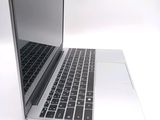a silver laptop with a black keyboard on a white surface
