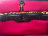 a close up of a black and pink purse with a gold zipper