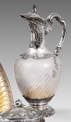 deux vases en argent et en verre et un plateau en argent posé sur un socle
