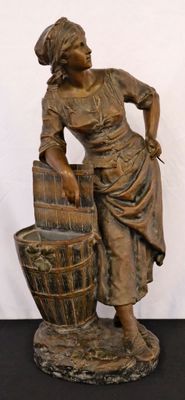 bronze statue of a woman with a bucket of water on a black surface
