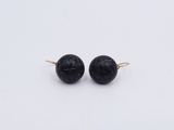 boucles d'oreilles en perles d'onyx noir sur fond blanc