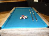 a pool table with a blue cloth and two billards on it