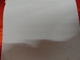 a white piece of paper with a red ribbon on it