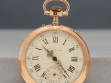 a gold pocket watch with roman numerals on it