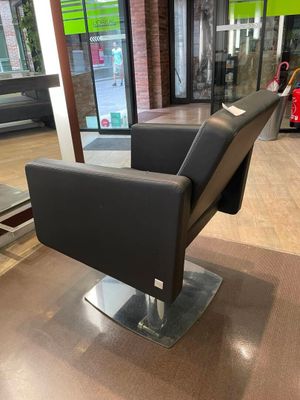 une chaise noire placée devant une fenêtre