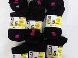 five pairs of black socks are stacked on a white surface
