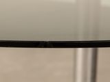 a close up of a glass table with a metal base