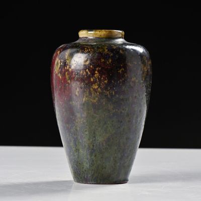 un vase posé sur une table à fond noir