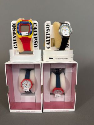 deux montres se trouvent dans une boîte posée sur une surface grise