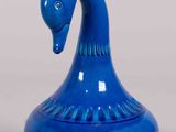 a blue vase with a bird on top of it