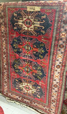 a rug on display in a store with a red chair