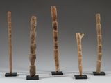four pieces of wood are arranged in a row on black stands