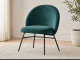 the green chair is next to a potted plant in a white room