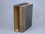 an old book sitting on top of a table next to a white wall