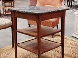 une table au plateau en marbre posée sur un tapis dans une pièce