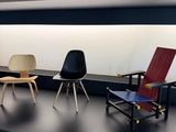 several chairs are lined up on a black shelf in a room