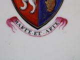 a picture of a plate with a coat of arms and a dog on it