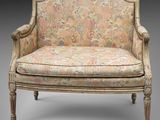 un fauteuil rembourré dont le dossier est orné d'un motif floral