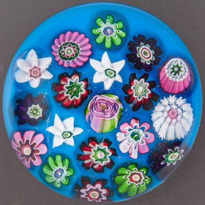 une assiette bleue décorée d'un bouquet de fleurs et de papillons