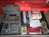 a red tool box with tools in it sitting on a table