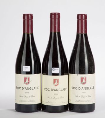 three bottles of red wine sitting on top of a white table