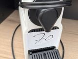 a white coffee machine with a black handle on a table