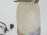 a glass jar that has a handle on it