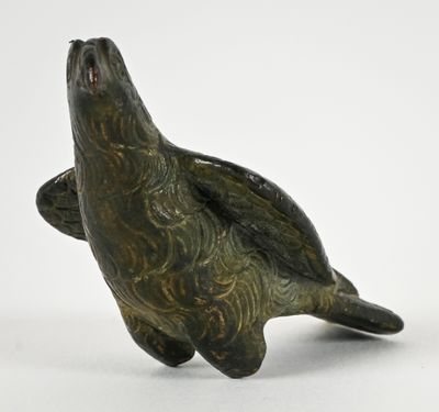 a bronze statue of a sea turtle on a white background